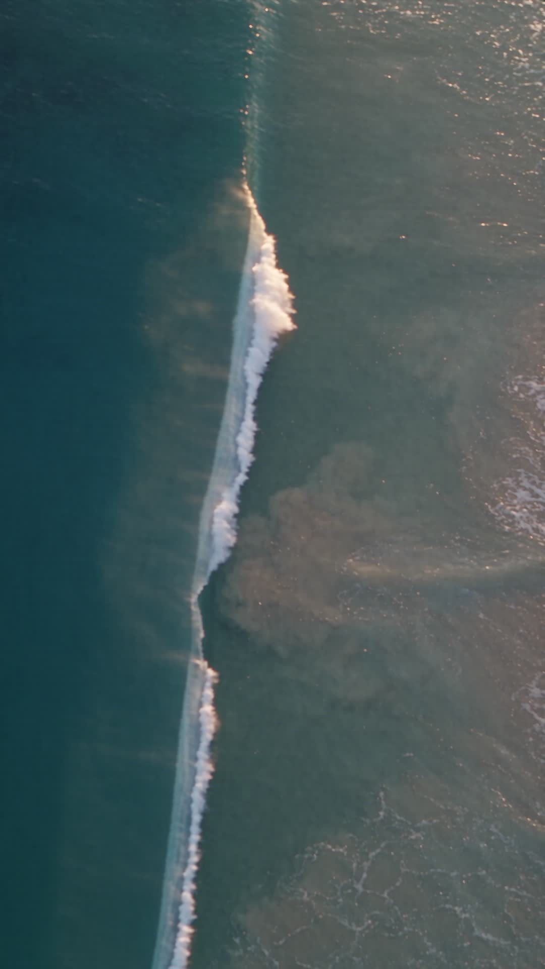 Aerial View of Ocean Waves Breaking at Golden Hour